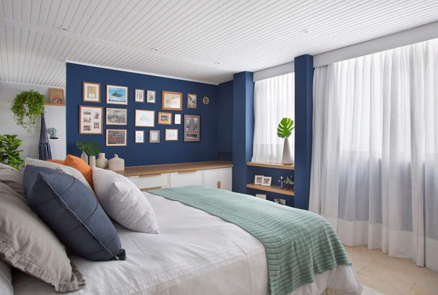 No dormitório, as paredes azuis acrescentam requinte e uma delas foi adornada com a montagem do gallery wall | Projeto Memoá Arquitetos | Foto: Raiana Medina