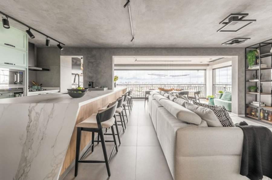 Cozinha, varanda gourmet, living e sala de jantar foram unidos na reforma deste apartamento, marcado pelo uso do cimento queimado, spots de iluminação, estante de serralheiras e bancadas que se tornaram as estrelas do projeto da BMA Studio | Foto: Guilherme Pucci