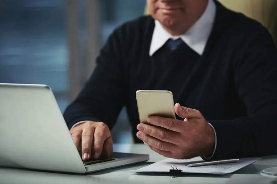 Cropped image of businesman reading messages on smartphone screen (Imagem: Divulgação)